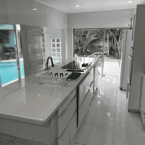 A black and white photo of a kitchen with a pool.